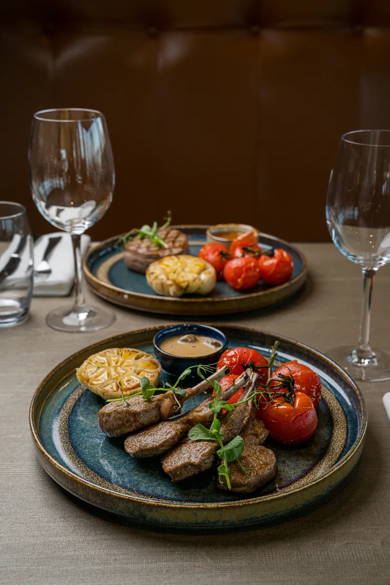 Deux assiettes dressées et des verres sur une table de restaurant, photographie TimFocus