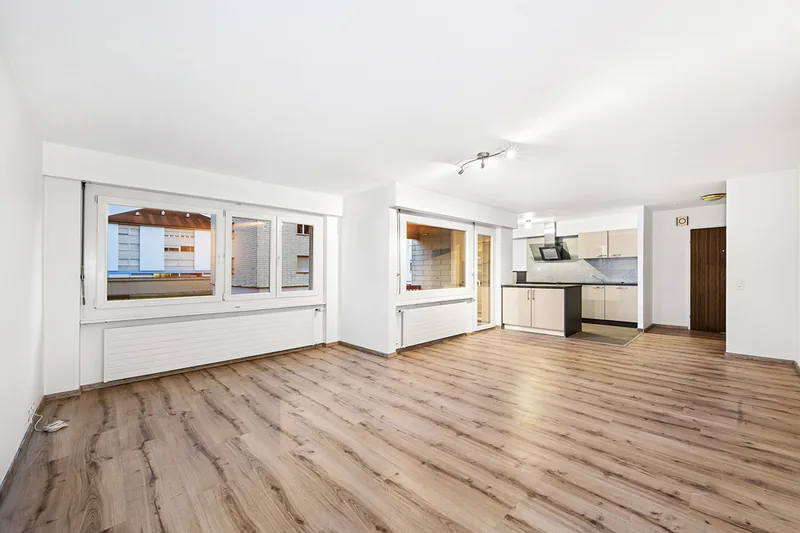 Pièce claire avec parquet, fenêtres et cuisine ouverte photographiée par TimFocus