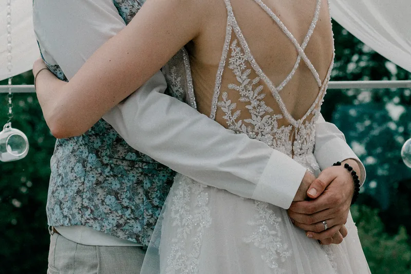 Le couple enlacé, détail de la robe de mariée