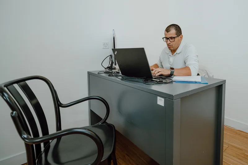 Un professionnel à son bureau devant un ordinateur, photographie TimFocus