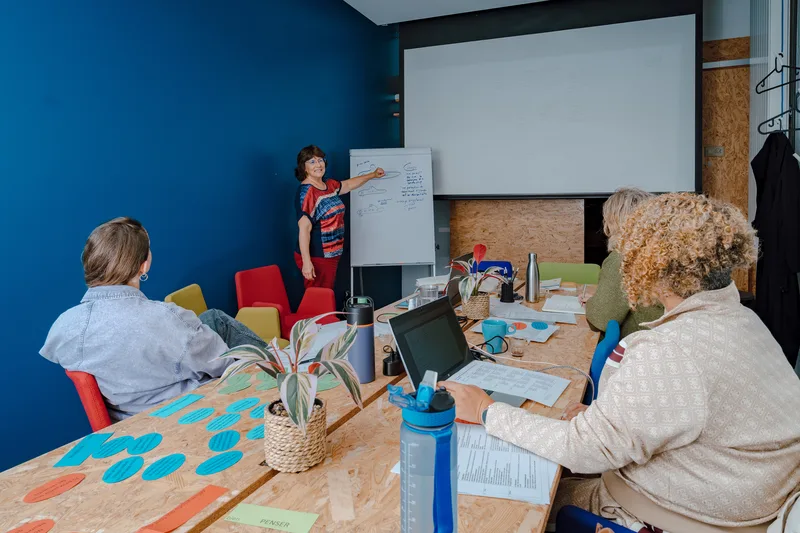 Une intervenante et des participantes autour d’une table pendant un atelier, photo TimFocus
